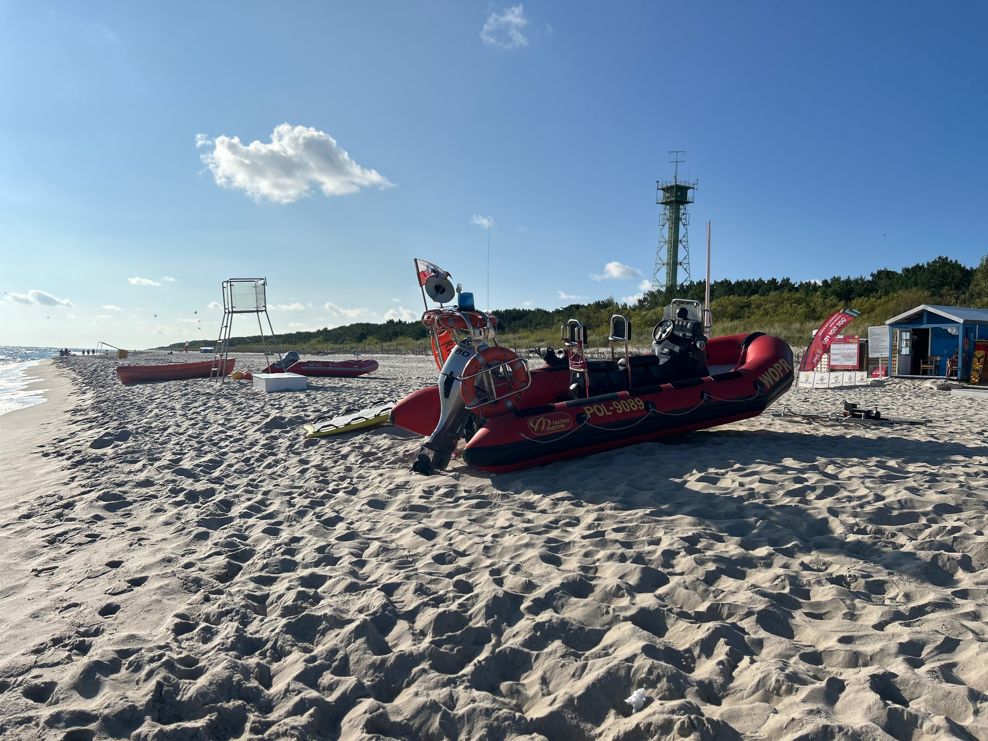 Lifeguard rescue boats stationed on the sandy beach - ready for action with the watchtower in the background