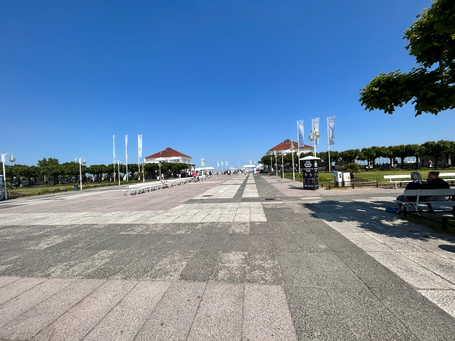 The elegant Sopot promenade - a sunny day stroll towards the famous pier with flags fluttering in the breeze