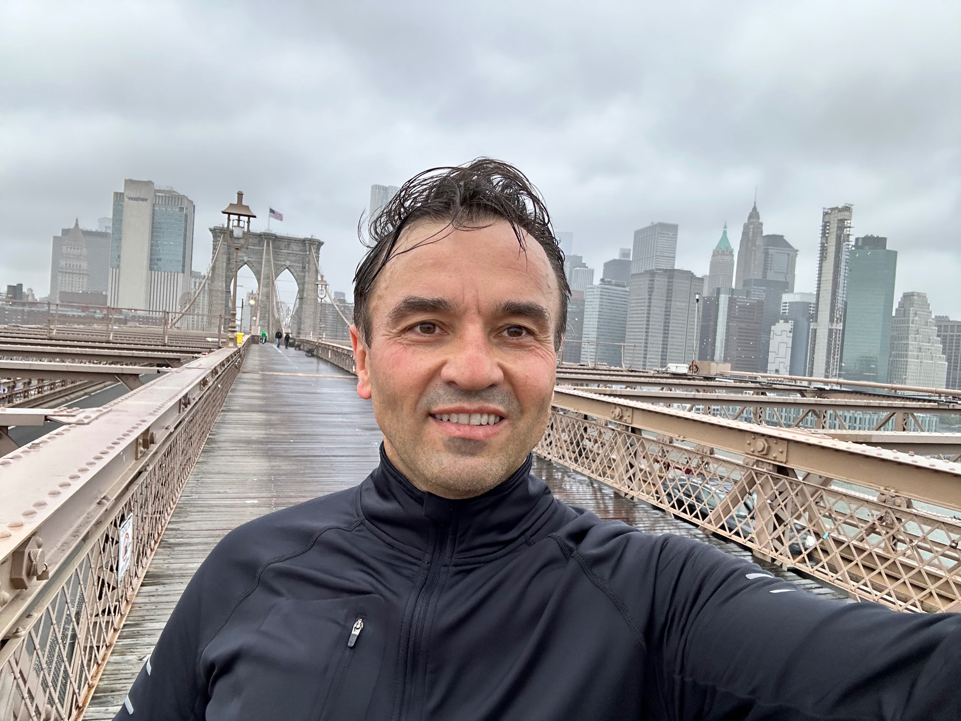Running across Brooklyn Bridge - the iconic Gothic arches framing the Manhattan skyline