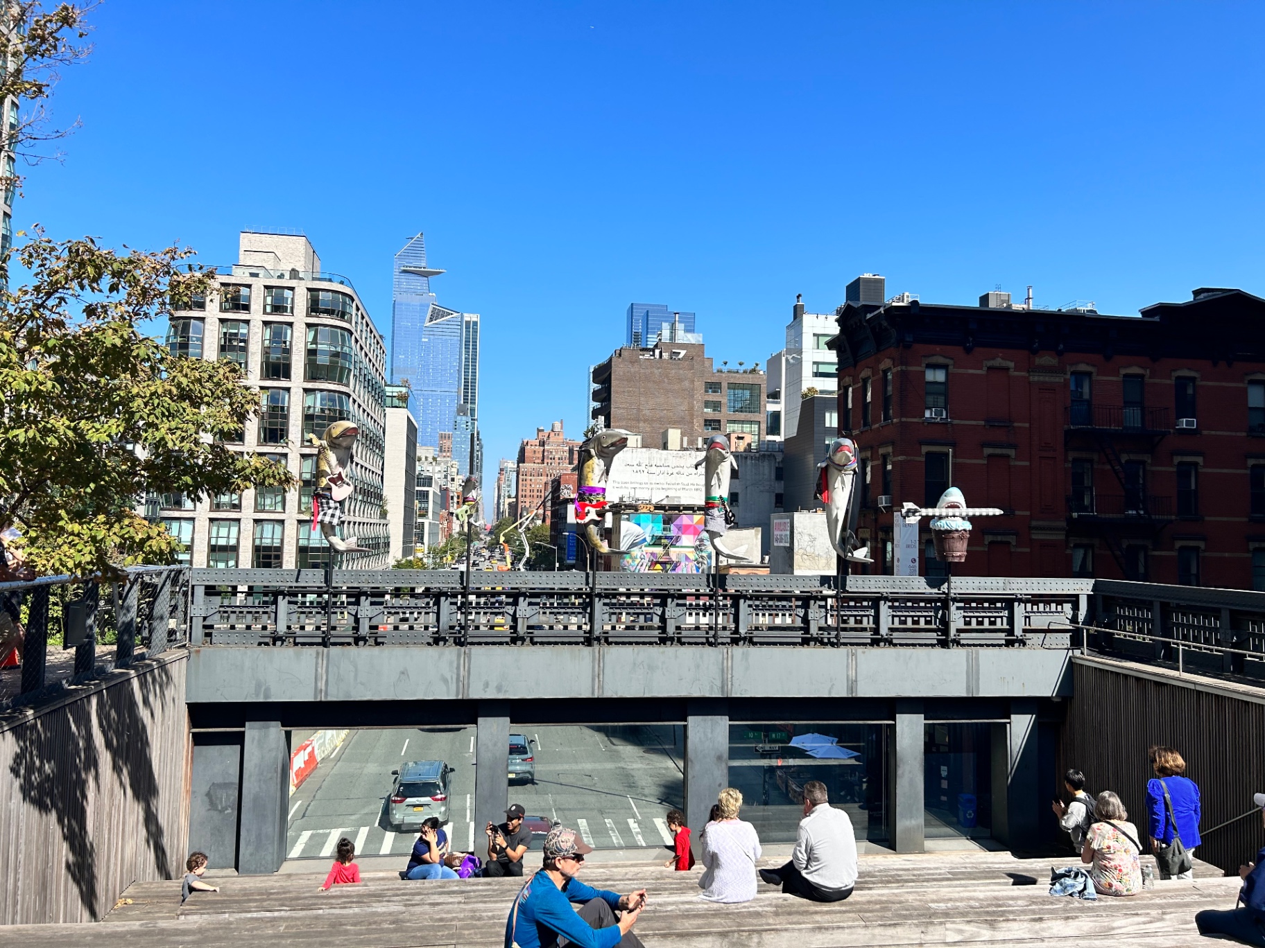 The High Line elevated park - visitors relaxing on urban steps with colorful sculptures and Manhattan skyline views