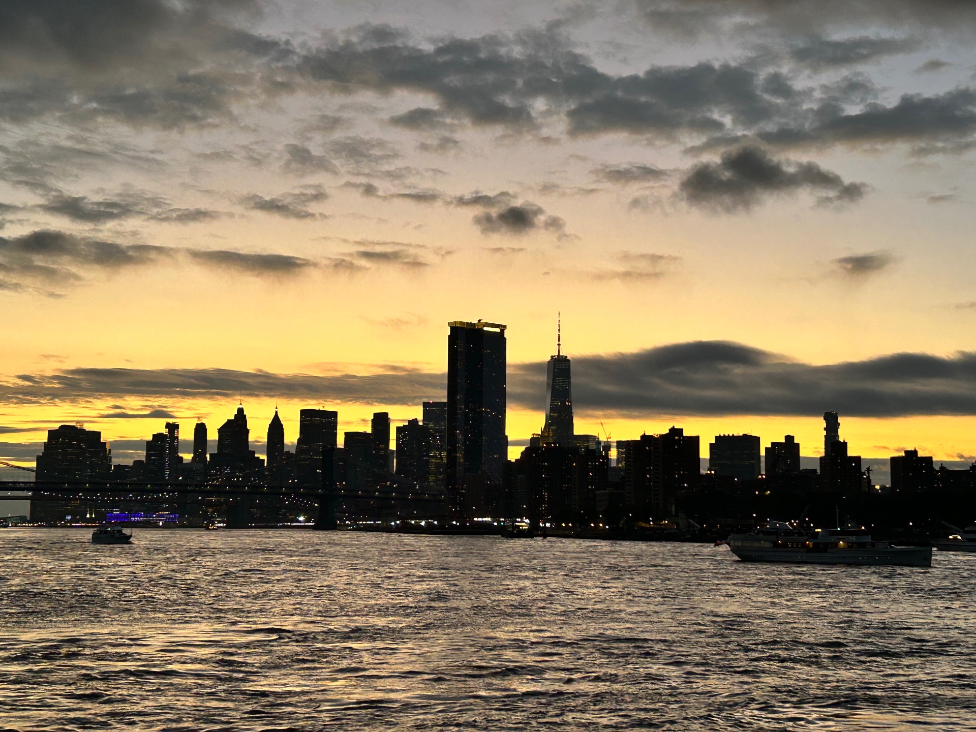 Manhattan skyline from the East River at dusk - One World Trade Center dominates the view